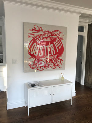 Decorative sign with 'The Lobster Pot' design on a wall above a white cabinet.